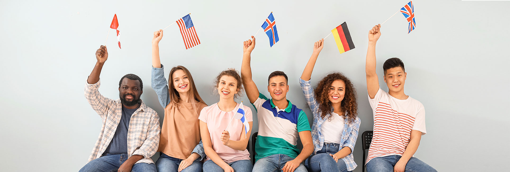  diverse group of individuals proudly displaying flags from various countries, symbolizing international student teaching.