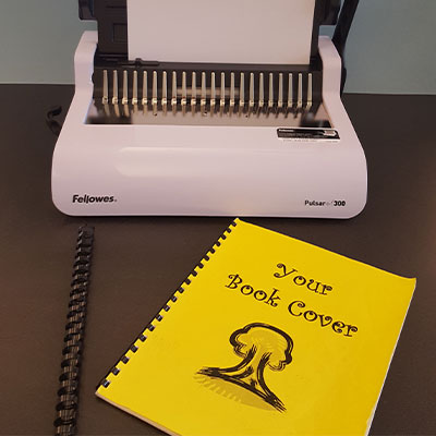 manual comb binder sitting on table.