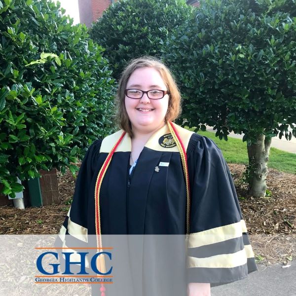 Ariel Bishop, smiling in a graduation gown, with the Georgia Highlands College logo in the bottom left corner.