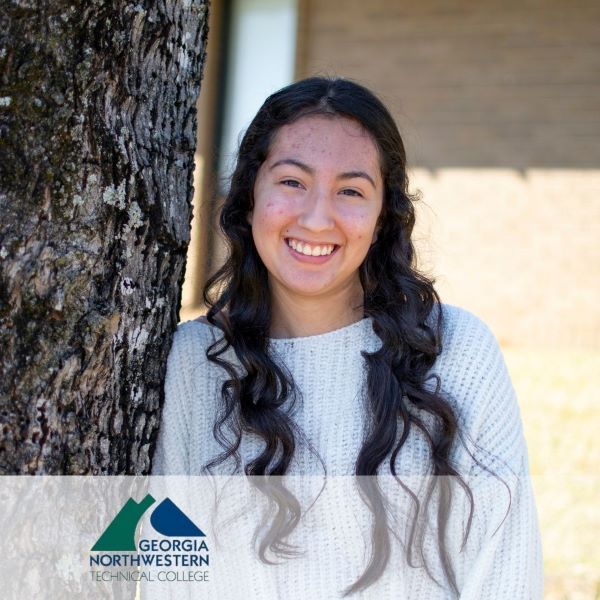Ashley Paramo-Carmona, smiling and leaning against a tree, with the Georgia Northwestern Technical College logo in the bottom left corner.