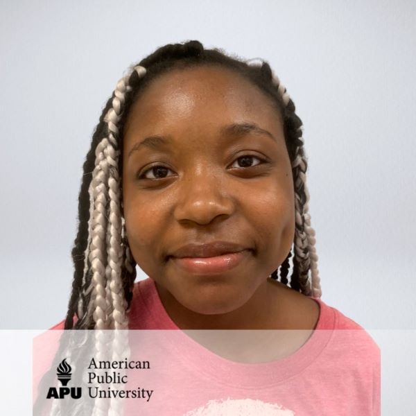 Aleem Thomas, in a headshot with a netural background.