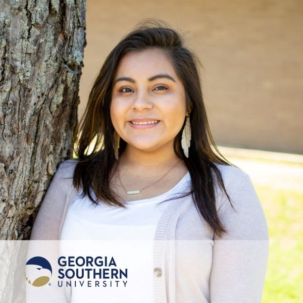 Marina Sosa Diaz, smiling and leaning against a tree, with the Georgia Southern University logo in the bottom left corner.