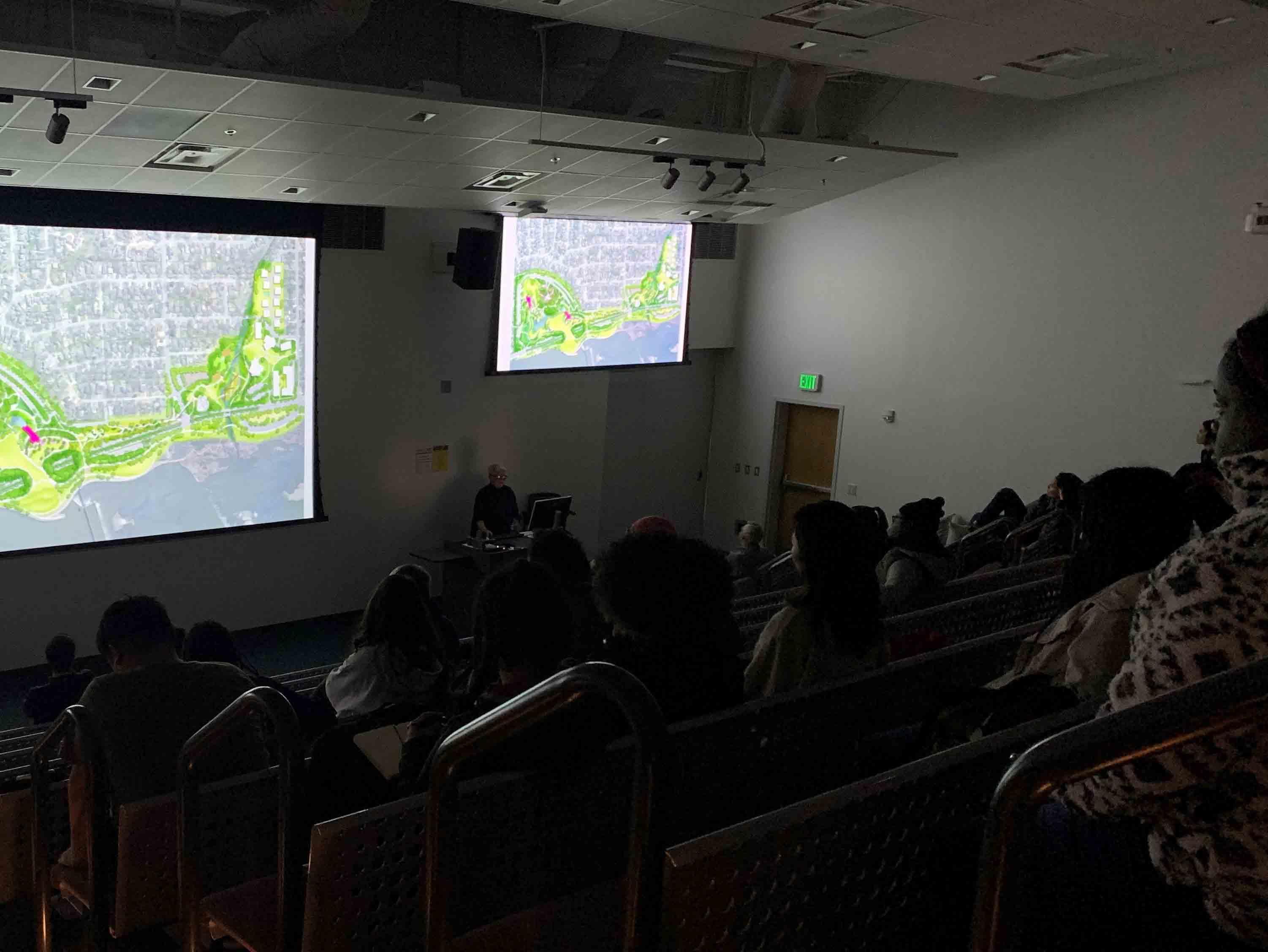  / Merrill Elam giving a presentation on a large screen  