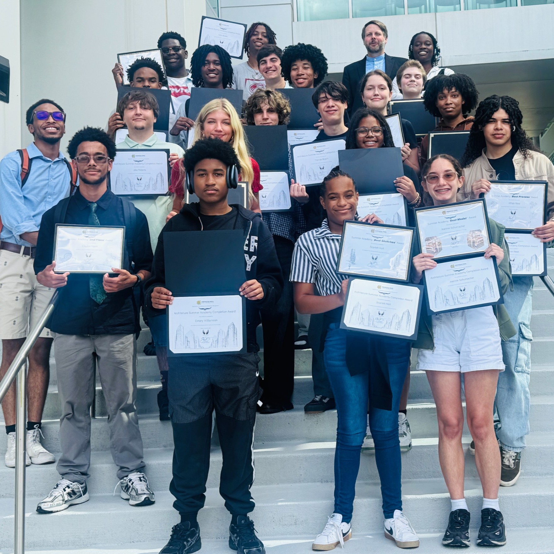 Students pose on the steps with their certificates for completing Arch Summer Academy.
