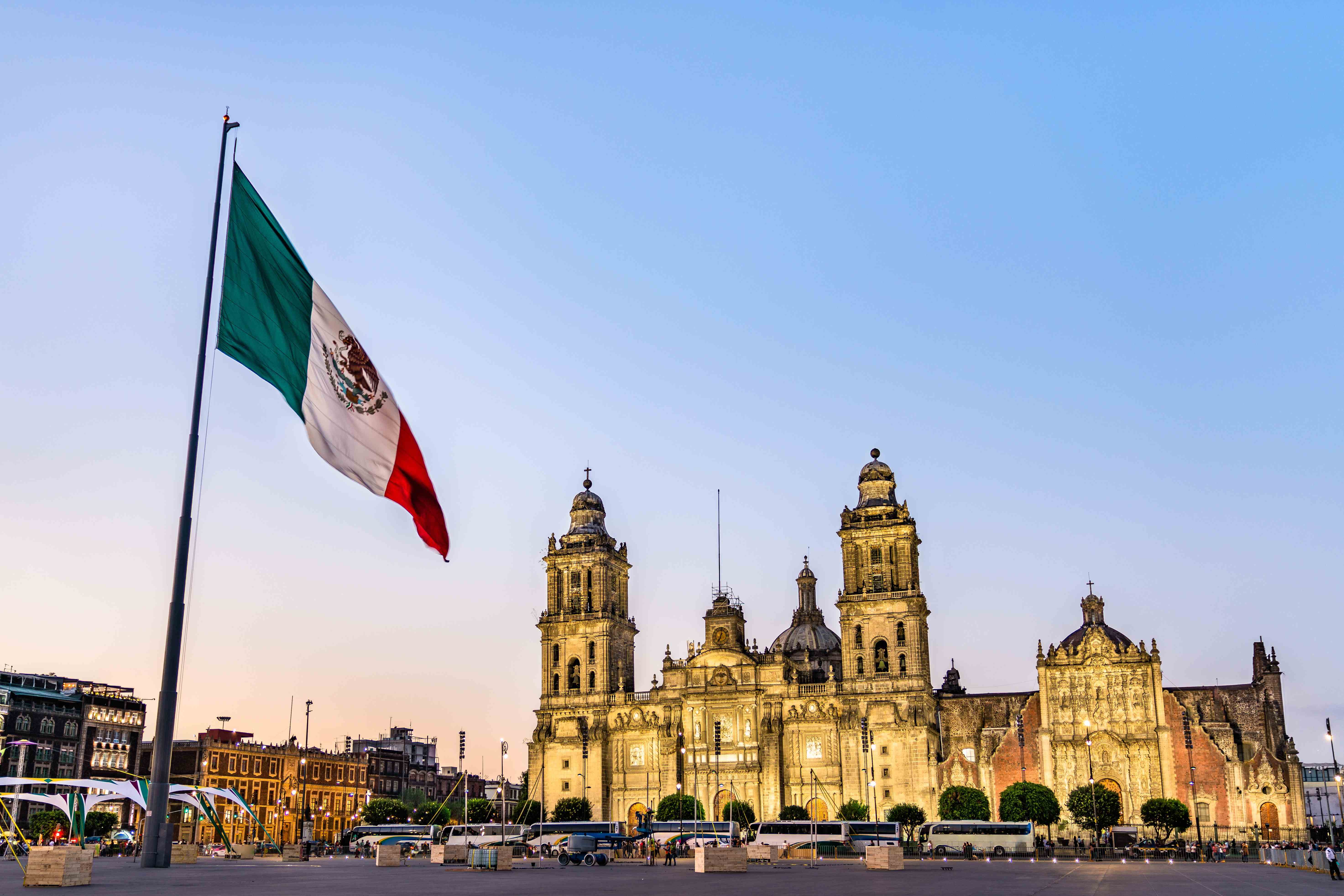 The Mexican flag flys in front of the Mexico City Metropolitan Cathedral.