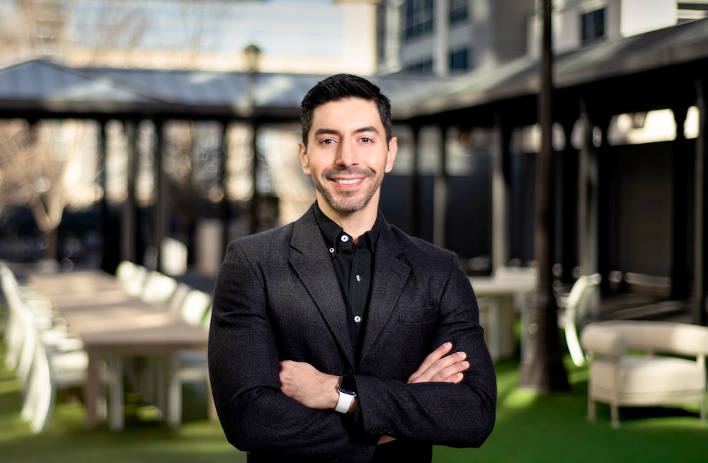 Luis Calvo poses in a lush courtyard. 