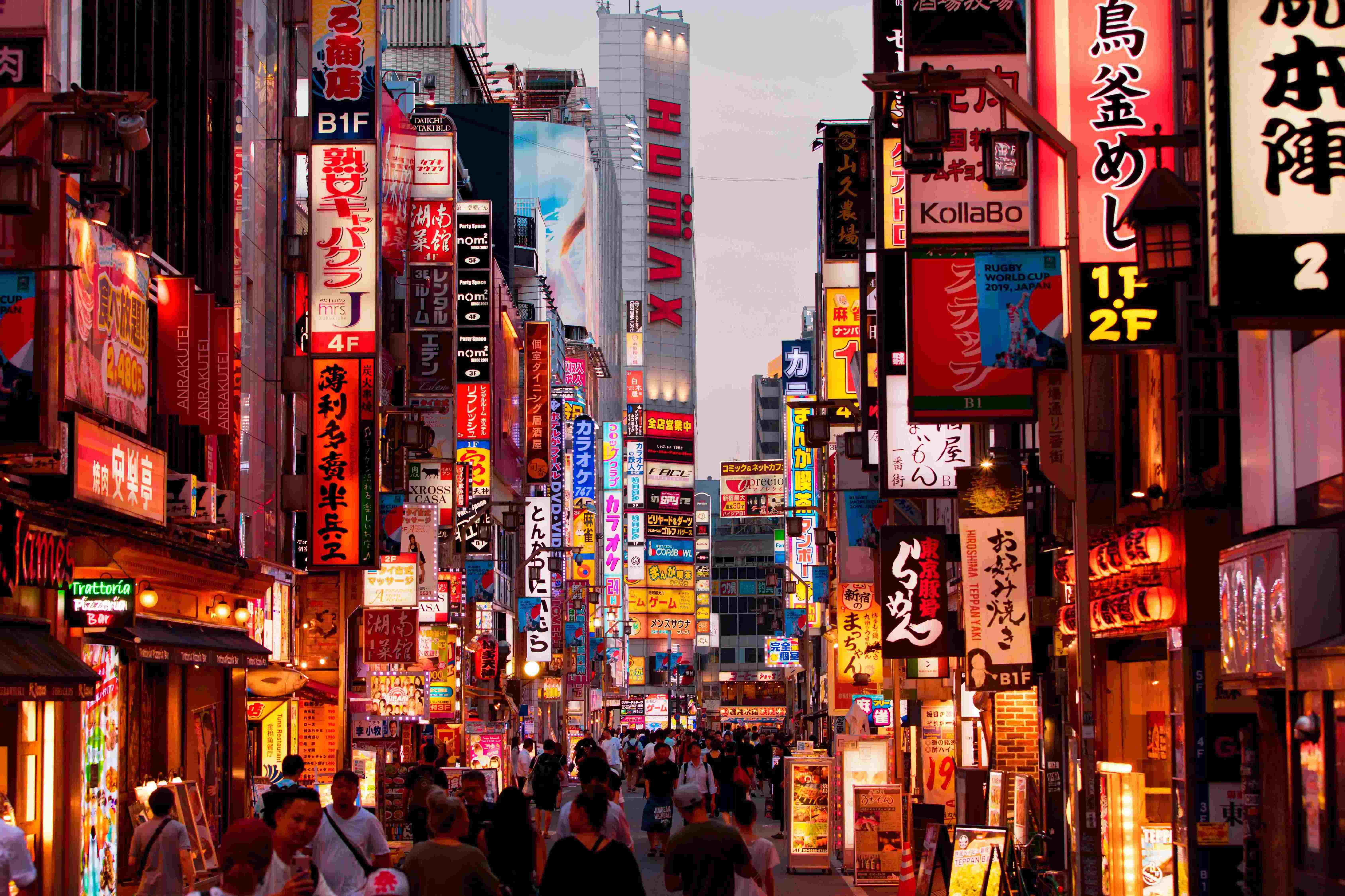 A vibrant street in Tokyo, Japan lined with many illuminated signs.
