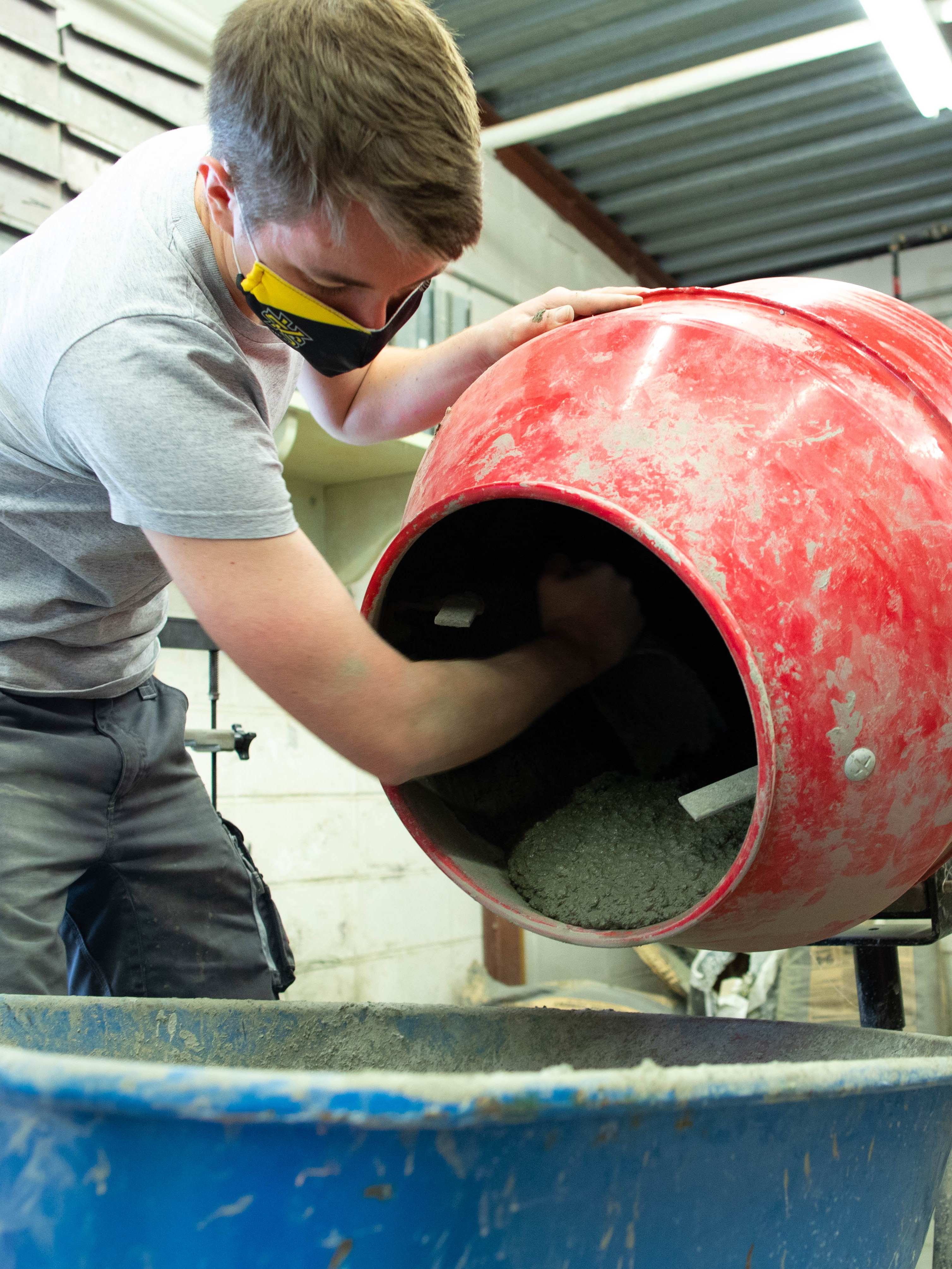 Student emptying a concrete mixer.