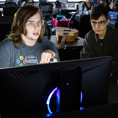 Two game design students review code during the Global Game Jam.