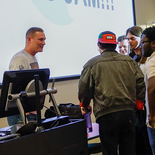 Event sponsor speaking with a group of students.