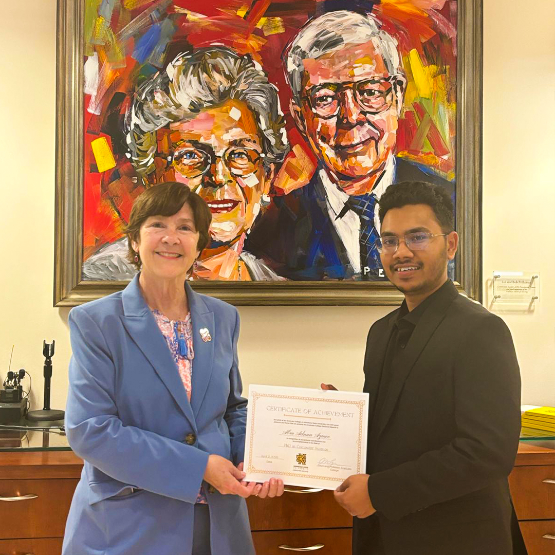 Abm Adnan Azmee smiling next to Dr. Langman holding his Doctoral Dissertatinon Award