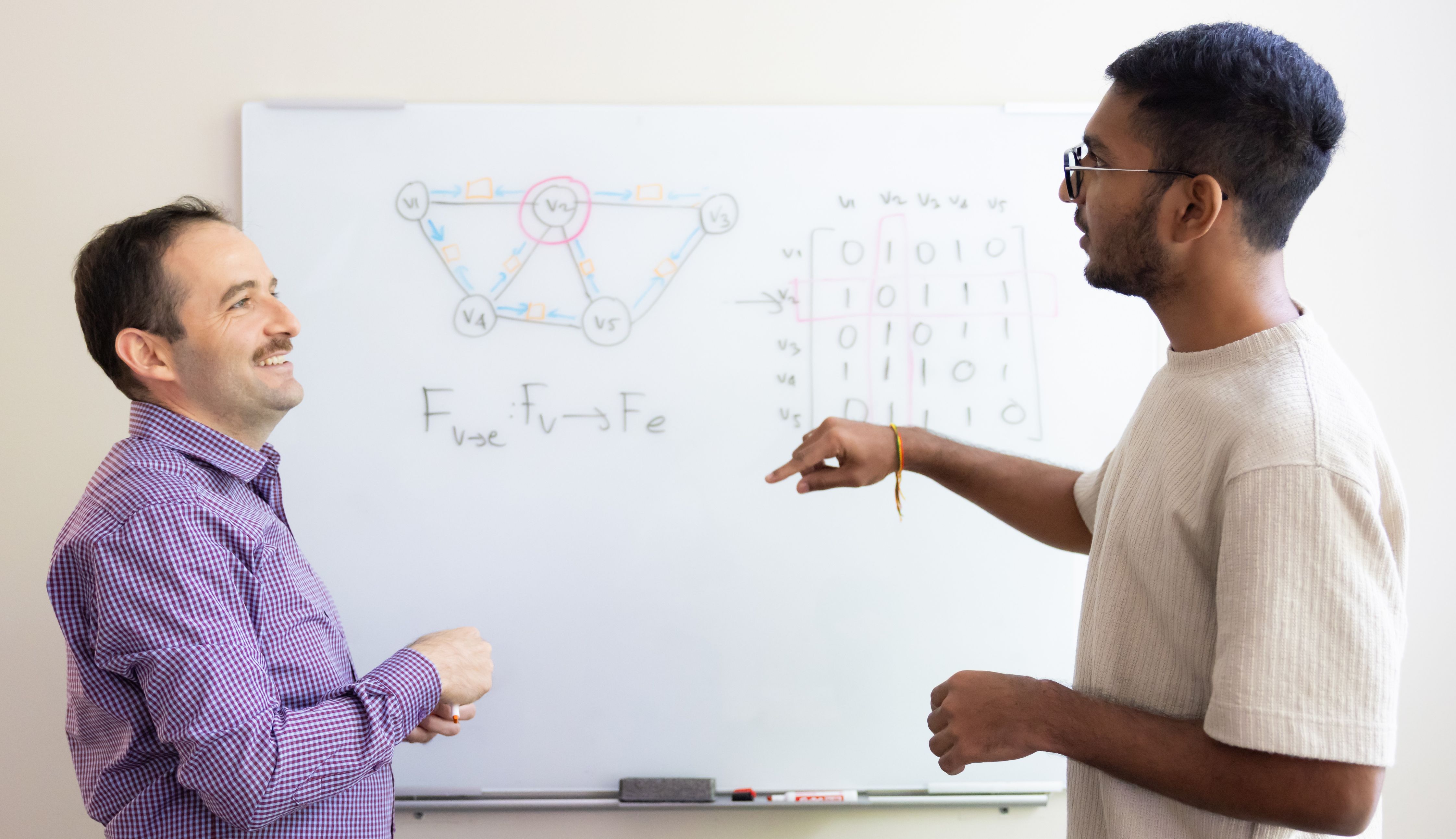 Student and Professor work in front of whiteboard
