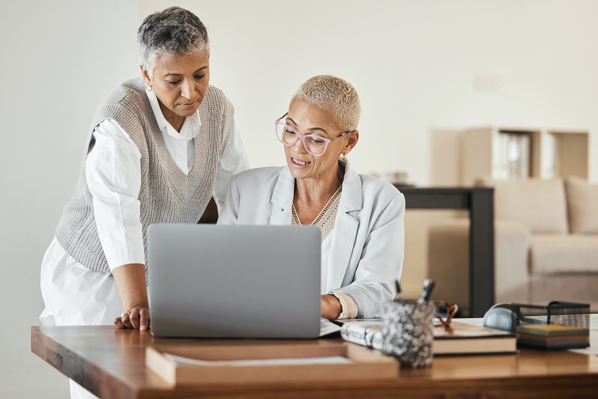 two woman working together on a laptop