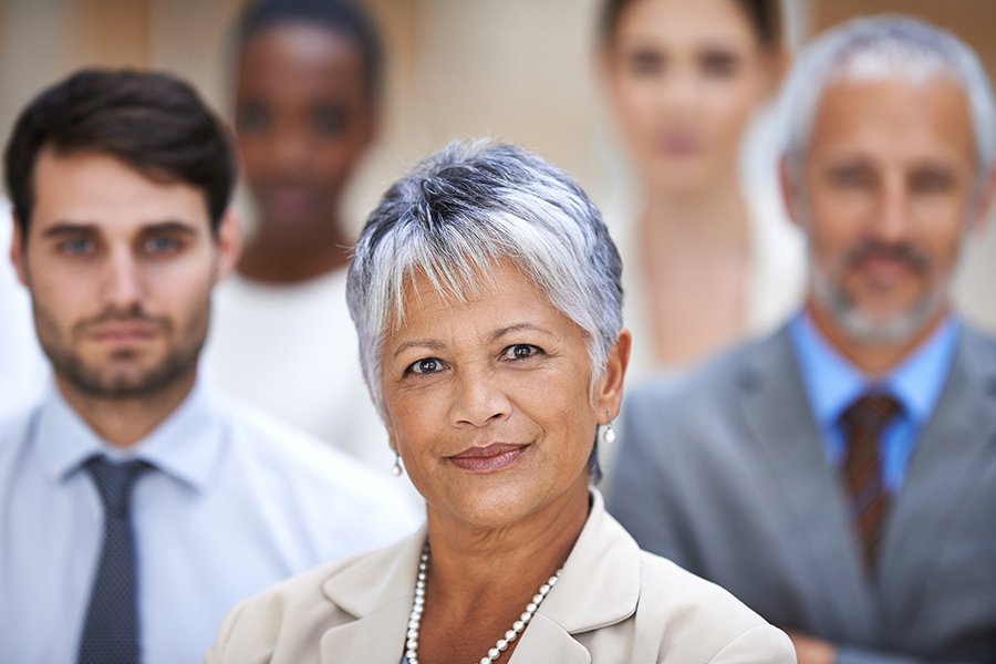 a woman stands in front of a group of coworkers