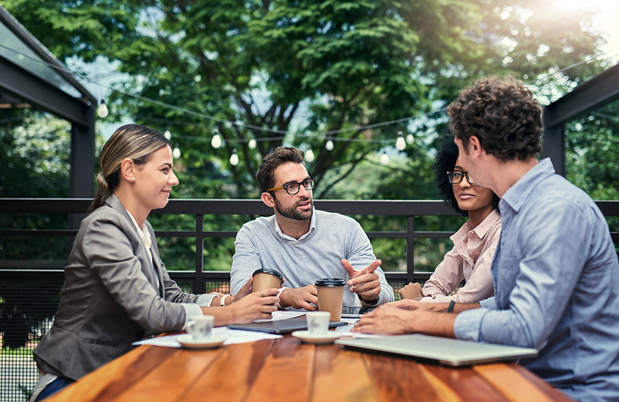 a group of people sitting at a table in an outdoor setting