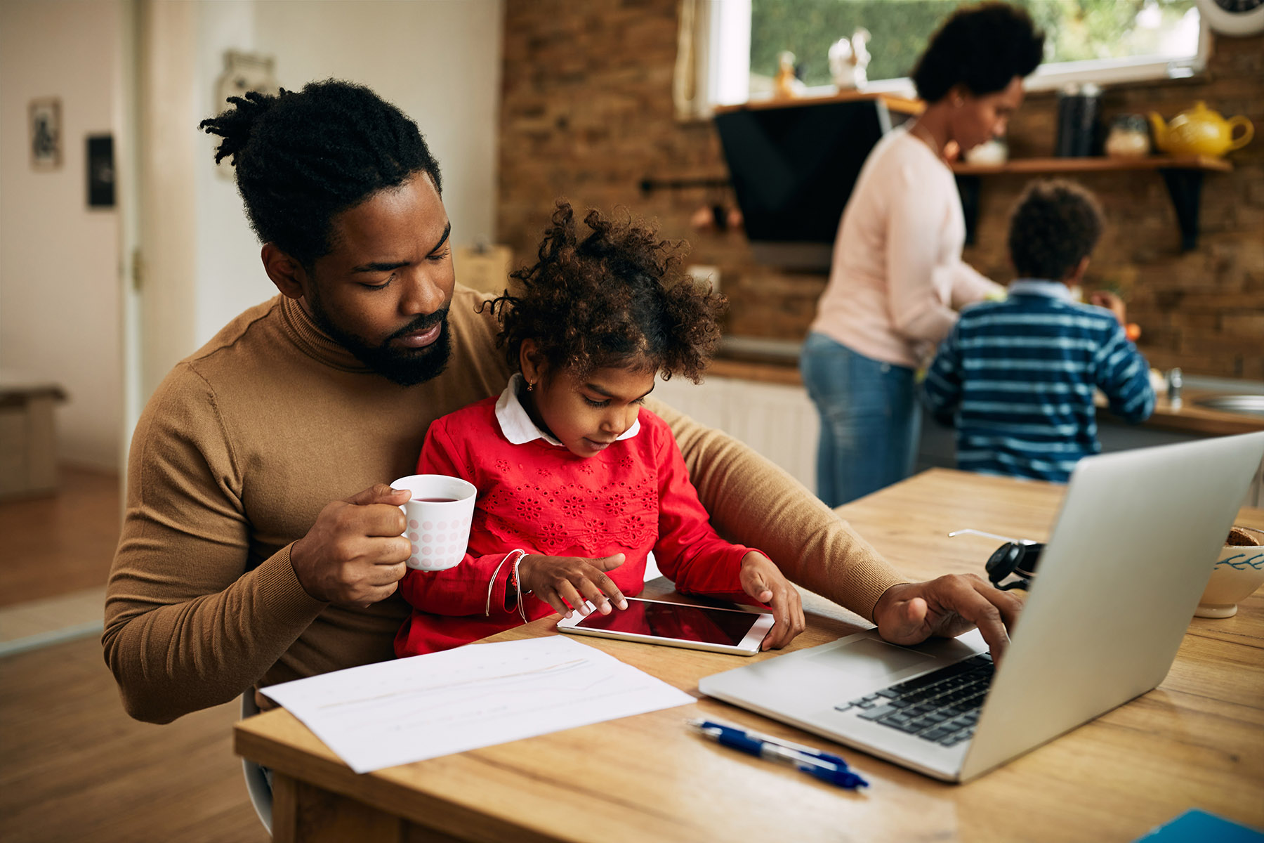 a man and his child work on a laptop