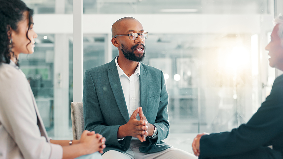 three people are talking together in a close circle