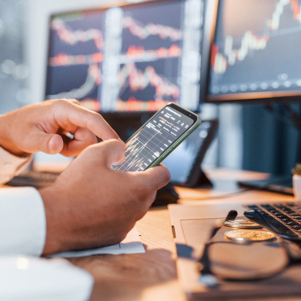 a person is viewing financial information on a cell phone at their desk
