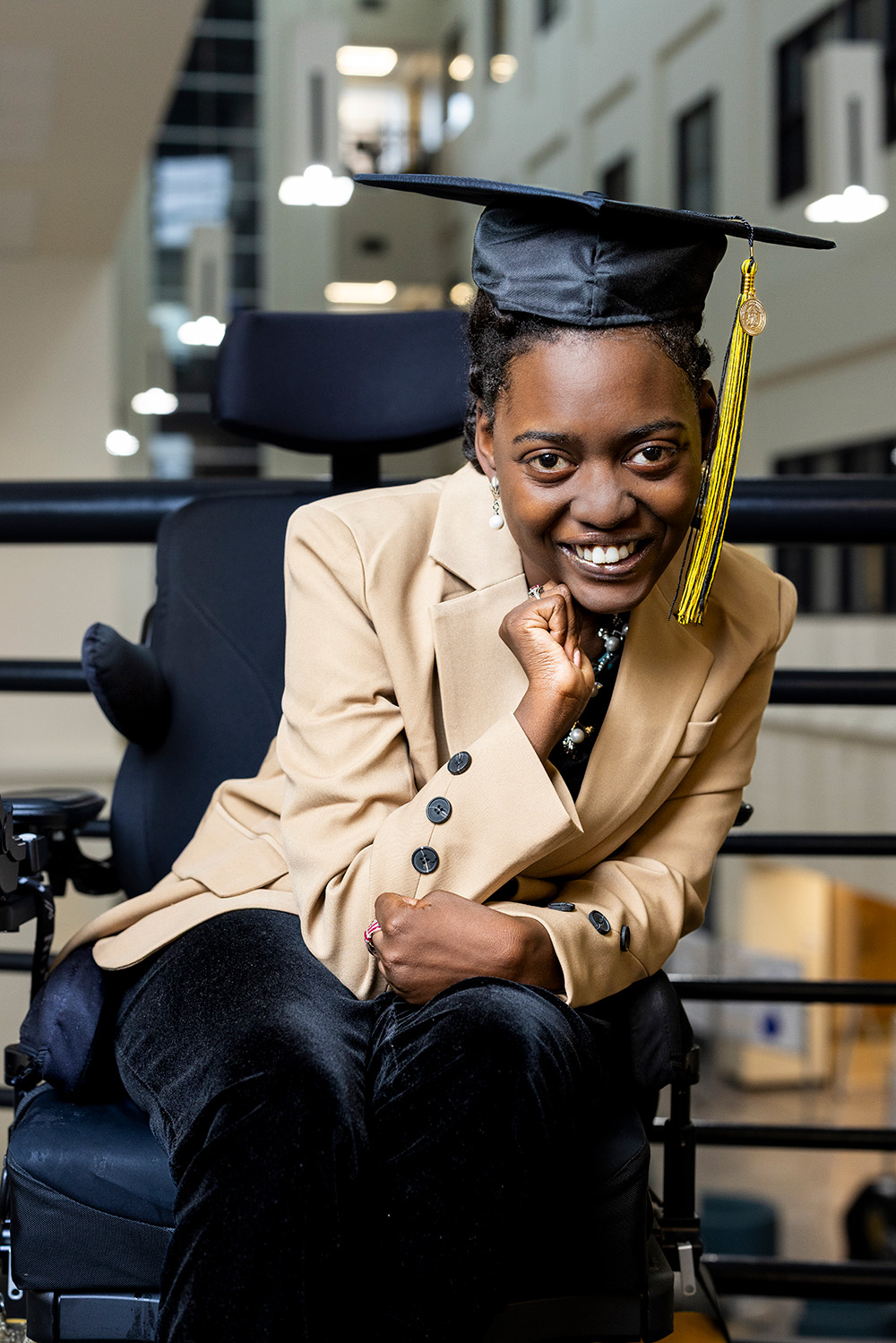 Brianna Jackson poses in her graduation cap in the Burruss Building Atrium