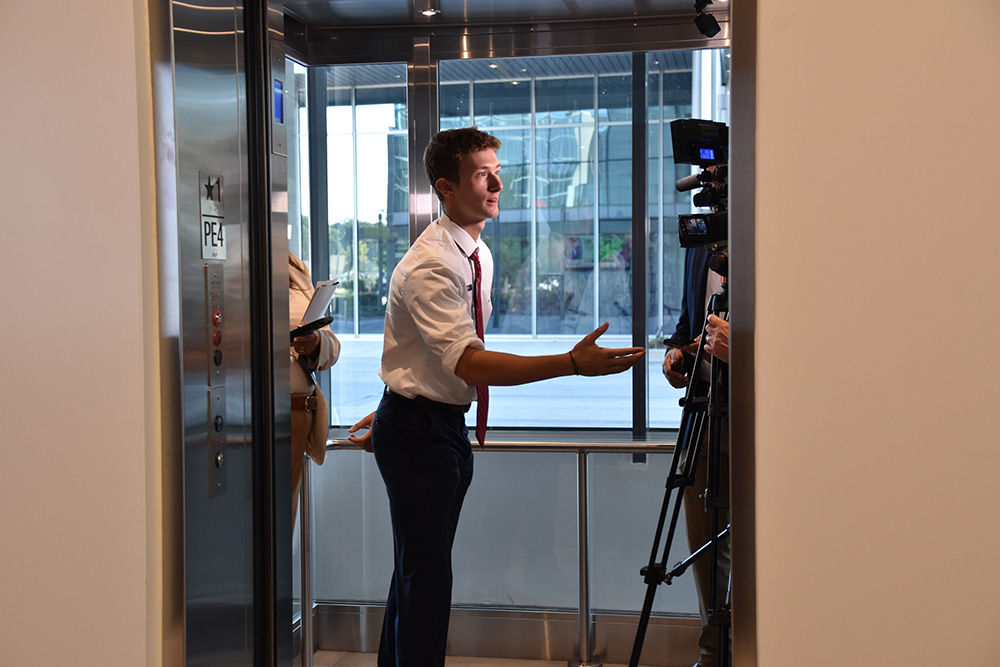 a student is reaching out his hand while making his elevator pitch