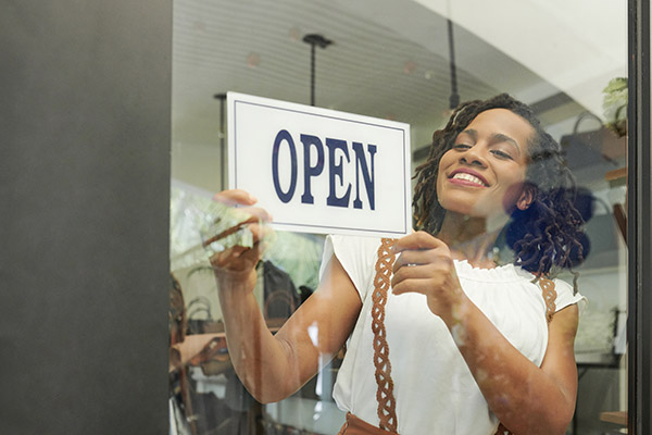 Cheerful woman opening store