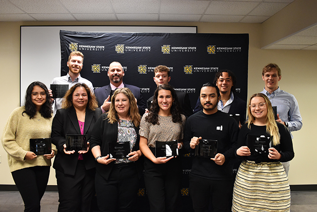 Student recipients of the Coles College Outstanding Student Awards displaying their award statues
