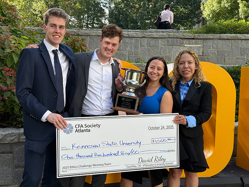 SMIF team members smile with their CFA trophy and cash prize