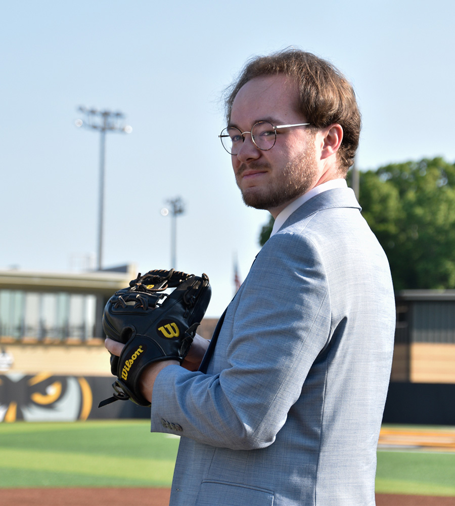 Joey Van Sickle stands confidently on a baseball field, glove in hand