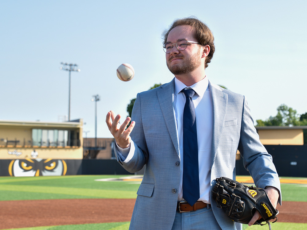 Joey Van Sickle tosses a baseball into the air on a KSU baseball field