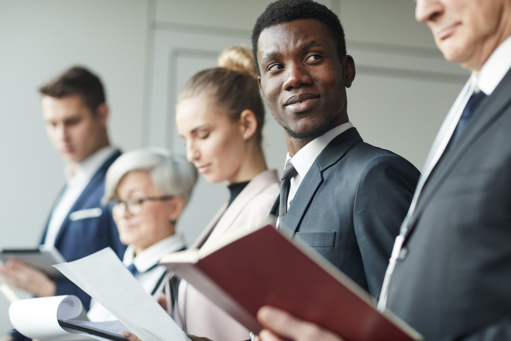 Business employees hold resumes in a line