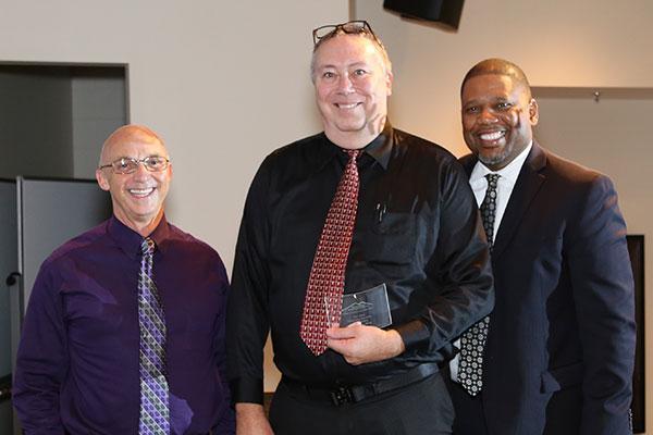  / (Left to right) Photo of Chris Stanford, Ph.D., Chair of the Department of Ecology, Evolution, and Organismal Biology (left), Distinguished Part-time Award recipient, Max Cocker, Ph.D., (middle), and Adrian Epps, Ph.D., Associate Dean for External Affairs (right). 