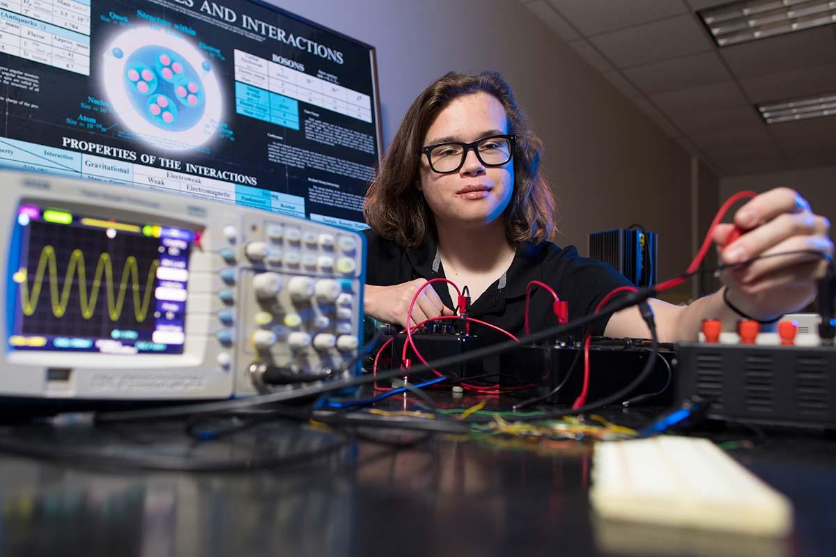 Physics student working on research with equipment.  / Physics student working on research with equipment. 