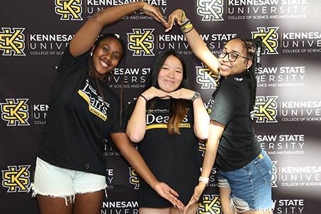 Three Kennesaw State University Dean's Scholars making a heart shape.