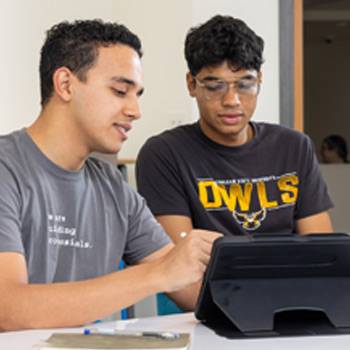 Students collaborate using a tablet during a classroom activity.