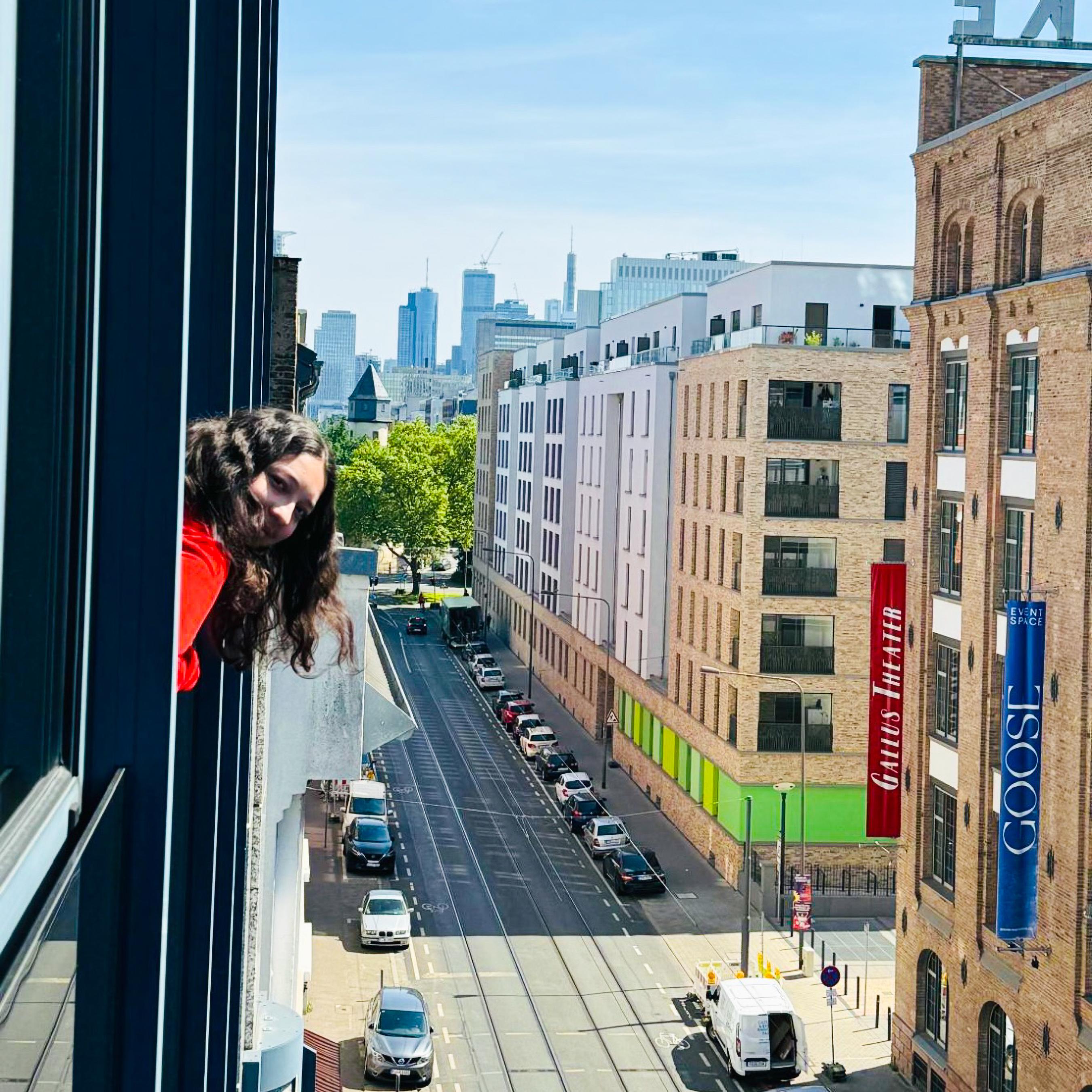 Kennesaw State University Honors student Gvantsa Kiknavelidze peers out of a window in a building in Germany.