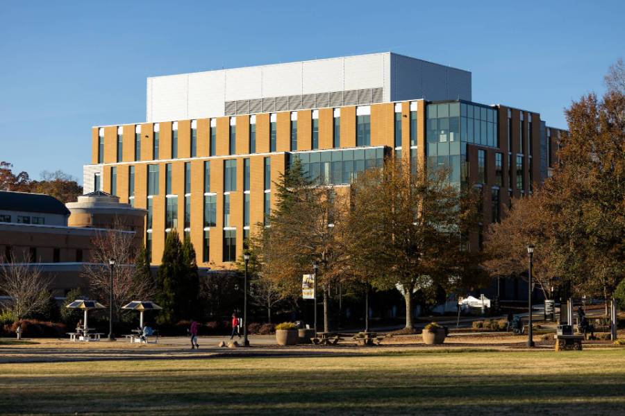 Building on KSU campus with large windows, trees, and people on a grassy area