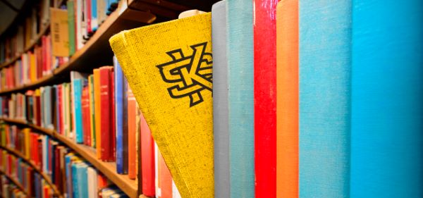 Colorful books displayed on a shelf in a library.