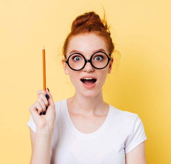 A woman holding a pencil with a yellow background