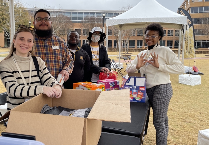 A group of five staff members outside at a table