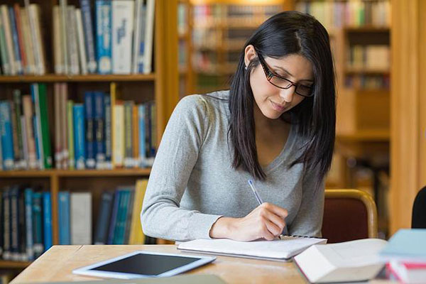 student in library writing