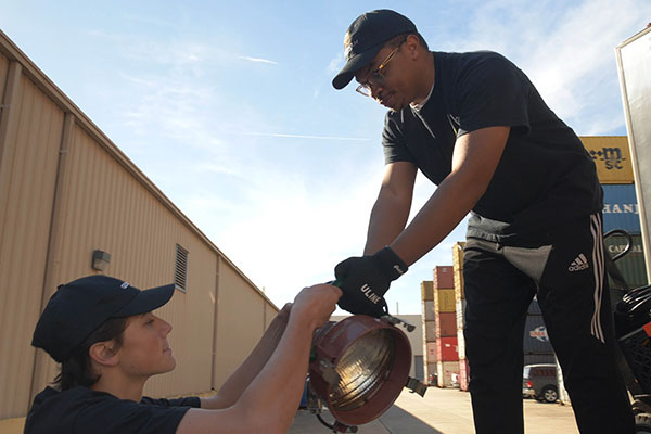students unloading lights from truck