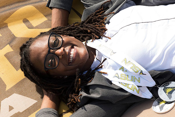 student laying on a ksu blanket on campus