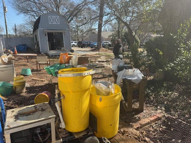 Archaeology site with barn in background and two yellow plastic tubs
