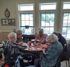A group of elderly women sitting at a table.