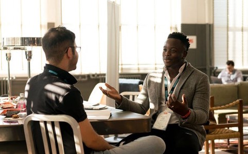 Two men conversing in an professional setting.