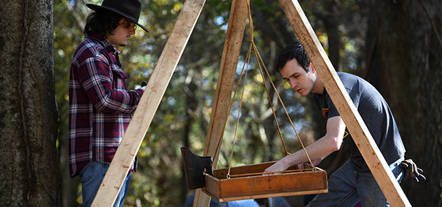 KSU Students looking at artifacts in a sifter box.