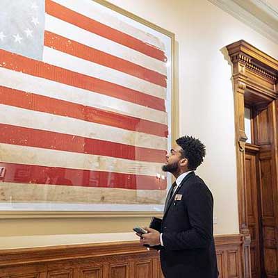 student admiring framed 13 star american flag