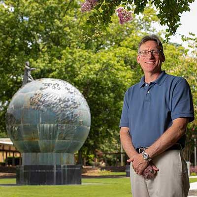 ksu professor and globe on campus