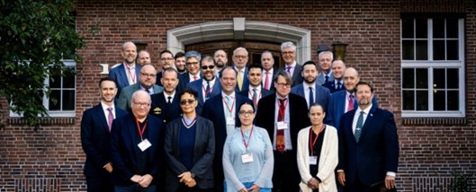 Student Gvantsa Kiknavelidze standing with members of the Annual Global Atlanticists Meeting posing in from of a brick building