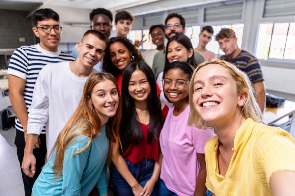 College students taking a group selfie in a classroom
